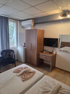 a hotel room with two beds and a television at Hotel Zara Rooms in Stara Zagora +6 photos