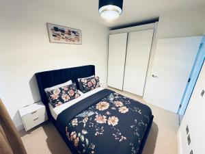 a bedroom with a bed with a black bedspread with flowers at Cozy Bedroom in a Townhouse Next to Jewellery Quarters and City Centre in Birmingham +1 photo