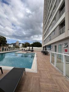 a swimming pool on the side of a building at Apto lindo e completo com piscina em Itajai in Itajaí