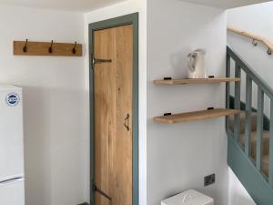 een hal met een houten deur en een trap bij The Spud Shed - Uk47419 in Curry Mallet