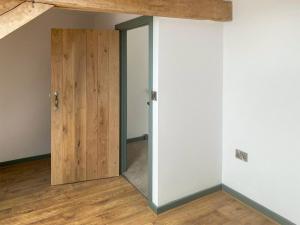 een open deur in een kamer met houten vloeren bij The Spud Shed - Uk47419 in Curry Mallet