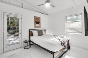 ein weißes Schlafzimmer mit einem Bett und einem Fenster in der Unterkunft Ventur Tropical with Elite Pool & Ultimate Fun Zone in Fort Lauderdale + 32 Fotos
