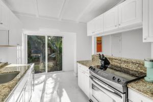 eine weiße Küche mit Spüle und Herd in der Unterkunft Ventur Tropical with Elite Pool & Ultimate Fun Zone in Fort Lauderdale