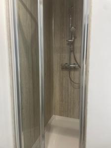 a shower with a glass door in a bathroom at Beachfront pet friendly townhouse, Stunning views in Port Talbot +22 photos