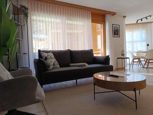 a living room with a couch and a coffee table at Altrove Leukerbad - Modern, Spacious & Central in Leukerbad