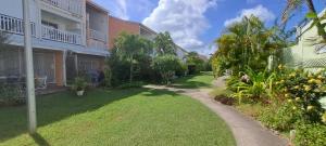 een tuin van een appartementengebouw met een pad bij Evasion Tropicale in Saint-François