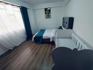 a small bedroom with a bed and a window at The Cliff in Nairobi