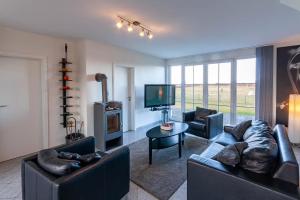 TV a/nebo společenská místnost v ubytování Ferienwohnung Arkonablick EG, Helle Wohnung mit 2 Terrassen und eigenem eingezäuntem Garten Hunde herzlich willkommen