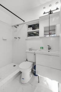 ein weißes Badezimmer mit Toilette und Waschbecken in der Unterkunft Ventur Tropical with Elite Pool & Ultimate Fun Zone in Fort Lauderdale