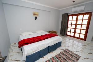 a bedroom with a large bed with a red blanket at Gentians Freedom House in Luxor +98 photos