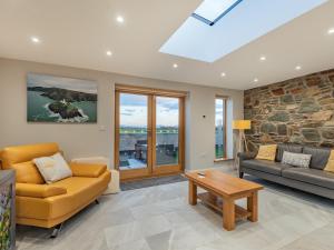 ein Wohnzimmer mit Sofa und Tisch in der Unterkunft Ty Cwtch in Holyhead