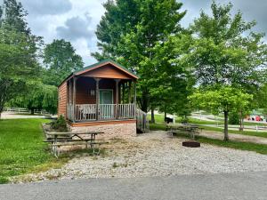 a small cabin in a park with two picnic tables at Jellystone Mammoth Cave in Cave City