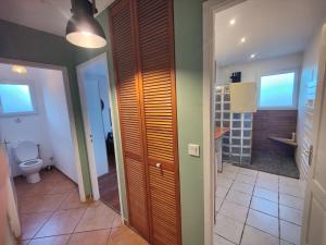 a bathroom with a toilet and a hallway with a door at La Suite Soleil in Gujan-Mestras +19 photos
