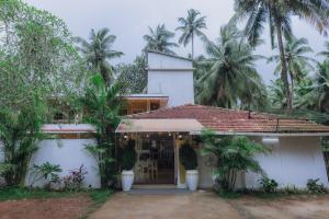 a house with palm trees in front of it at Pvt Pool - Villa Azura Escape Marialina Calangute in Saligao