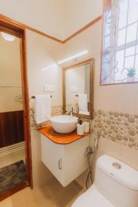 a bathroom with a sink and a toilet and a mirror at Pvt Pool - Villa Azura Escape Marialina Calangute in Saligao