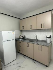 een keuken met witte kasten en een witte koelkast bij Royal Suit in Bandırma