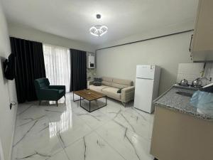 een keuken en een woonkamer met een bank en een koelkast bij Royal Suit in Bandırma +13 foto's