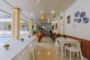 a restaurant with white tables and white chairs at Pvt Pool - Villa Azura Escape Marialina Calangute in Saligao