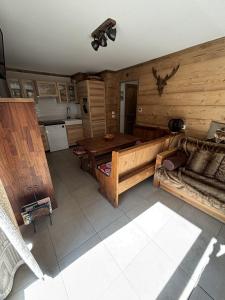 a living room with a table and a kitchen at Les 7 laux immobilier chalet F in Prapoutel