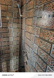 La salle de bains est pourvue d'un mur en carrelage et d'une douche. dans l'établissement Plaza Room Guest House, à Abrekuma