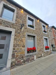 a brick building with red flowers in windows at Loft urbain style Brooklyn in Profondeville