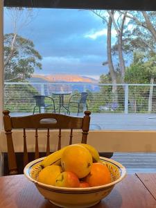 a bowl of fruit on a table in front of a window at Govetts Leap lookout cottage with sauna in Blackheath