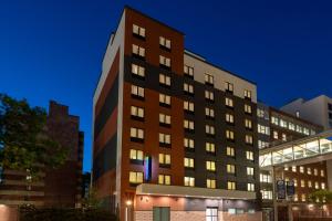 a tall brown building with lights on at Holiday Inn Express & Suites Bronx - Zoo Area by IHG in Bronx