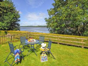 eine Terrasse mit einem Tisch und Stühlen auf dem Rasen in der Unterkunft Inglenook Cottage in Landshipping + 16 Fotos