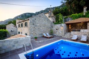 a house with a swimming pool in front of a building at Luciana by Vintage Travel in Mihanići