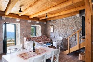 a living room with a table and chairs and a stone wall at Luciana by Vintage Travel in Mihanići