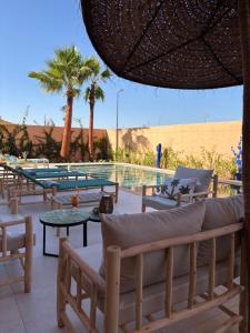 a resort with a pool and chairs and a table at Villa Marleanis 5 suites 300m2 piscine chauffée privative 11m de long résidence avec gardien in Marrakesh
