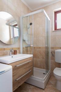 a bathroom with a shower and a sink and a toilet at Sele by Vintage Travel in Gruda