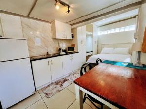 a kitchen with a bed and a table in a room at White Pearl at Strand in Strand