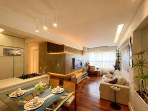 a living room with a couch and a table at Brisas do Cabo Branco by Hosppedar in Tambaú