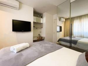 a hotel room with a bed and a flat screen tv at Brisas do Cabo Branco by Hosppedar in Tambaú