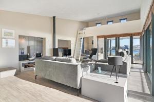 ein Wohnzimmer mit zwei Sofas und einem Tisch in der Unterkunft Luxury Beachfront Villa 4p - Uitzicht op de Baai & Duinen - Villa 19 in Ouddorp