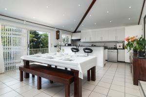 a kitchen with a white table and benches in it at Jacqueline Drive 51 in Ballito