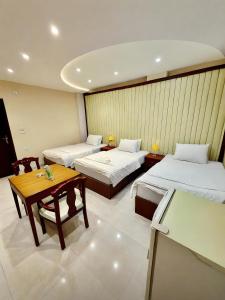 a hotel room with two beds and a table at Pyramids & SphinX Grand Hotel in Cairo