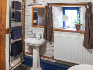 une salle de bain avec un lavabo et une fenêtre dans l'établissement Thatched Cottage - Uk50261, à Llandeilo 3 autres photos