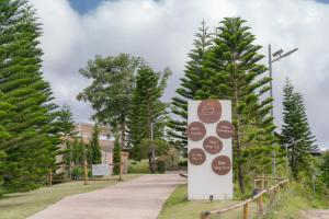 考科Area21 Khaokho的公园里有一块牌子，周围都是树。