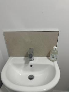 Un lavabo blanco en un baño con espejo. en The Courtyard, en Navan