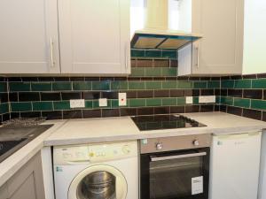 a kitchen with a stove top oven next to a dishwasher at 9A Market Square in Stonehaven