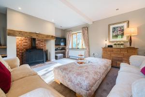 a living room with two couches and a fireplace at Orchard House 140 in Blakeney