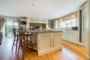a kitchen with a large island with bar stools at Orchard House 140 in Blakeney +21 photos