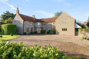 a large stone house with a large driveway at Orchard House 140 in Blakeney