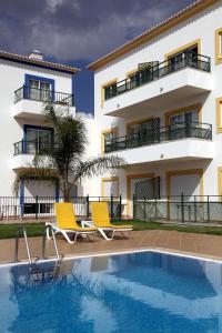 a building with two chairs next to a swimming pool at Alagoa Azul in Altura