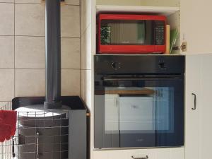 a microwave sitting on top of a stove in a kitchen at The Shepherd's Hut in Herstmonceux