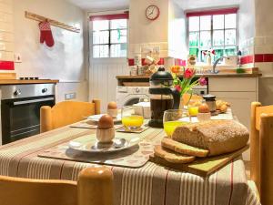 a kitchen with a table with bread and orange juice at Lightfoot House in Redmire