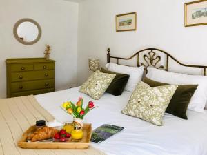 a tray of fruit and bread on a bed at Lightfoot House in Redmire