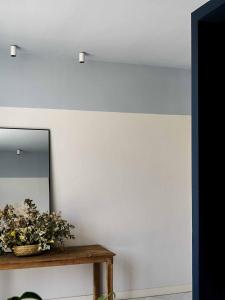 un espejo y una mesa con una planta. en Azul & Limón Apartments, en Córdoba